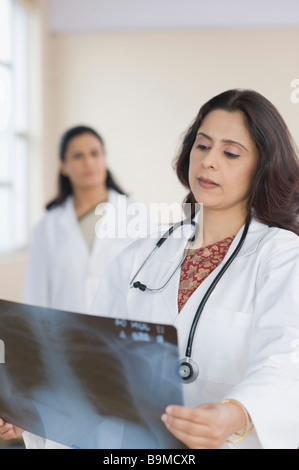 Femme médecin l'examen d'une x-ray report Banque D'Images