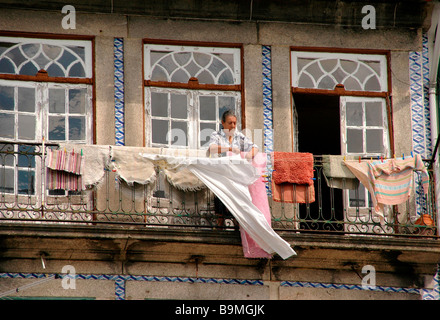 Une femme passe son temps à sécher les vêtements d'un Balcon. Télévision Porto - Portugal. Banque D'Images