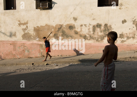 Deux garçons jouent au base-ball dans la rue à Santiago de Cuba Banque D'Images