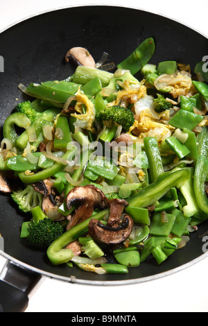 Un végétarien wok,avec,oignon,champignons,brocoli,chou chinois et mange-tout poivron vert cuisson dans un wok. Banque D'Images