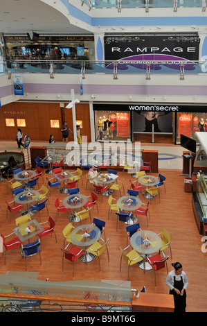 Abu Dhabi Marina shopping mall interior coin repas au moment du petit-déjeuner avec des tables et des chaises avec des magasins au-delà Banque D'Images