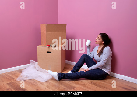 Une jolie jeune femme prend une pause pendant son transport de maison Banque D'Images