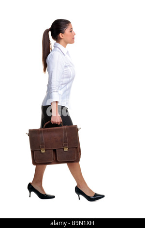Young attractive businesswoman walking along portant un cartable en cuir brun isolé sur fond blanc Banque D'Images
