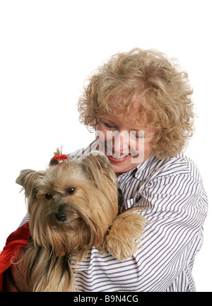 Un affectueux propriétaire donnant une accolade à son petit chien yorkshire Isolated Banque D'Images