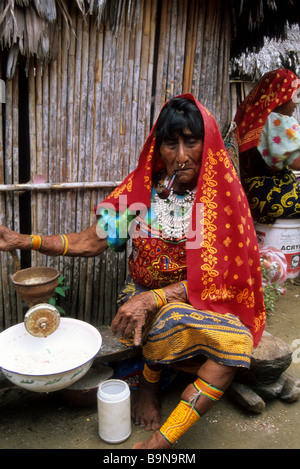 Dame Kuna fumant une pipe à l'extérieur de la cabane bambou, îles San Blas, Panama Banque D'Images