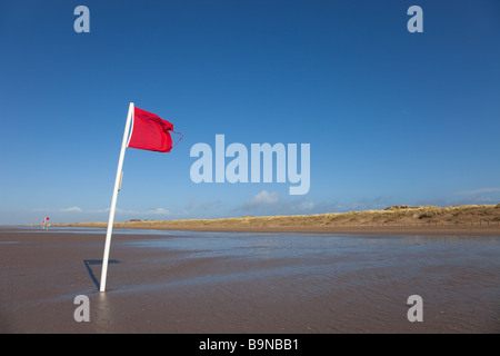 Plage rouge d'un drapeau dans le vent fort Banque D'Images