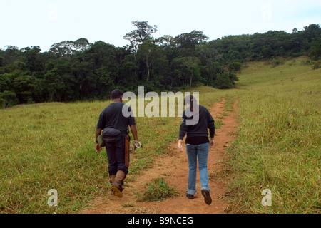 Deux personnes marcher dans un chemin de terre menant à un fragment d'une forêt tropicale, Caratinga, Minas Gerais, Brésil Banque D'Images