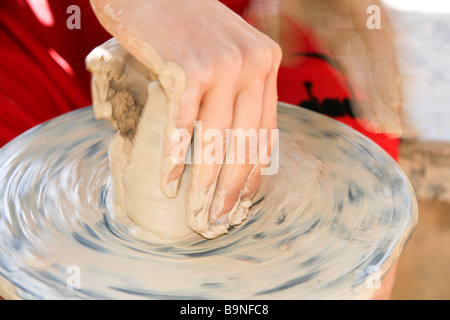 Les jeunes adolescents de sexe féminin faisant un pot en argile sur une roue potters Banque D'Images