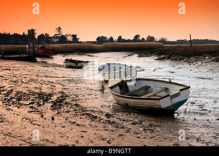 Vieux bateaux inutilisés se trouvant à marée basse, les marais salants de la côte nord du comté de Norfolk [Royaume-Uni]. Banque D'Images