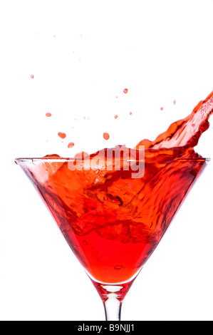 Un cube de glace éclabloussures dans un martini rouge boisson alcoolisée Banque D'Images