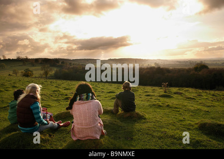 Les enfants regardant le coucher du soleil sur la colline Banque D'Images