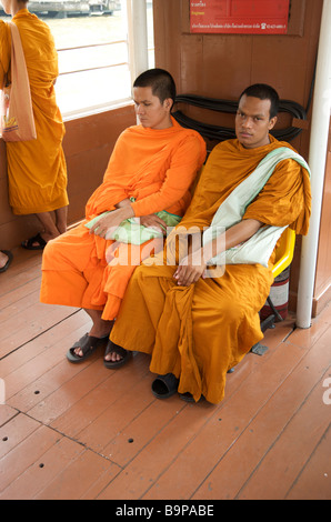 Deux moines bouddhistes assis sur une rivière en bateau taxi à Bangkok en Thaïlande Banque D'Images