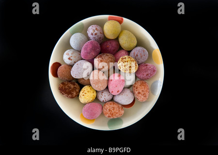 Mini oeufs de Pâques dans un plat sur un fond noir. Banque D'Images