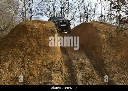 Une Land Rover Defender 90 sur le point de descendre une pente raide sur une piste de conduite hors route dans le Sussex au Royaume-Uni. Banque D'Images