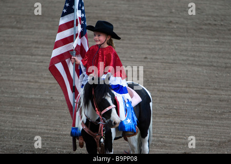 Jeune fille horse rider avec le drapeau Américain Cody Nite Rodeo Bretagne France Banque D'Images