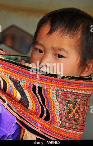 Jeune garçon Hmong en cours sur sa mère de retour près de Sapa Vietnam Banque D'Images