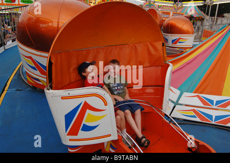 Deux garçons dans le tilt-a-whirl amusement park ride au Dutchess County Fair à Rhinebeck, NEW YORK Banque D'Images