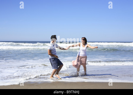 Jeune couple playing in surf Banque D'Images