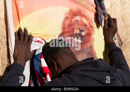 Israël Jérusalem Vieille Ville mur Ouest Close up of African man priant au mur avec lion sur le drapeau Banque D'Images