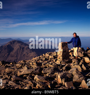 Femme par cairn sur sommet de Scafell, avec grand Gable en arrière-plan, Parc National de Lake District, Cumbria Banque D'Images