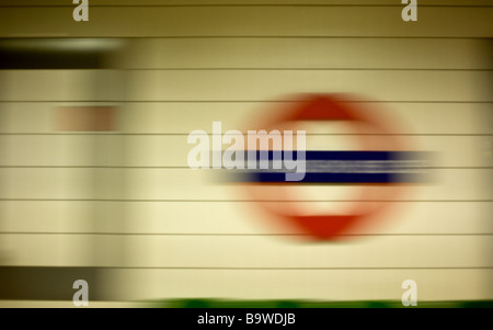 Train de tube d'accélérer au-delà d'un métro de Londres signe. Banque D'Images