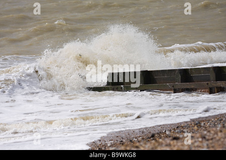 Vagues se brisant sur épis West Sussex UK Banque D'Images