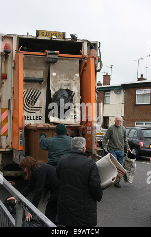 Les personnes apportant leurs déchets à un camion poubelle dans la rue, Killyleagh Castle, en Irlande du Nord Banque D'Images