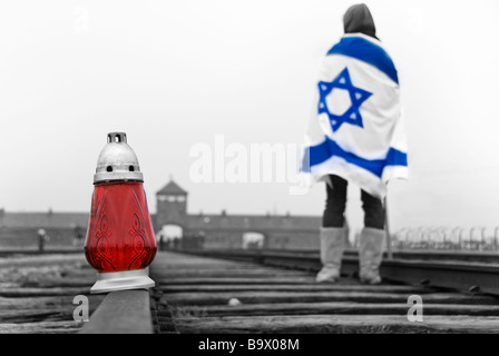 Fille avec un drapeau israélien à la recherche aux portes du camp de concentration d'Auschwitz-Birkenau, en Pologne, en Europe Banque D'Images