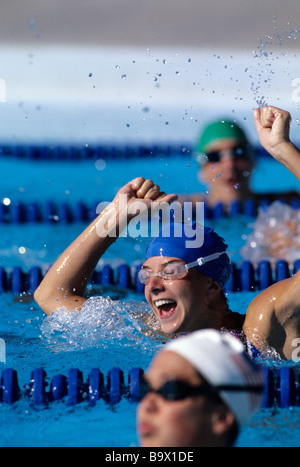 Femme célèbre sa victoire dans la course de natation Banque D'Images