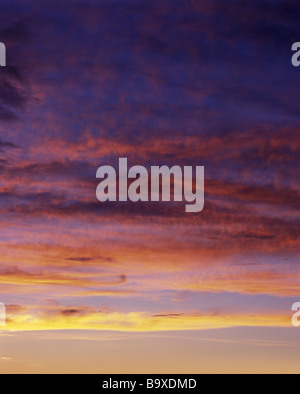 CLOUDSCAPE DE BANDES HORIZONTALES DE ROUGE JAUNE NUAGES SUR CIEL LUEUR ROSE Banque D'Images