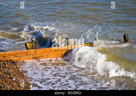 Vague s'écraser sur un brise-lames sur une plage de galets. Banque D'Images