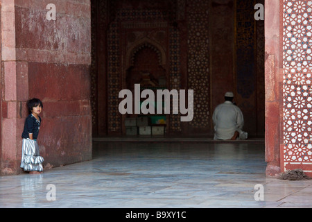 Jeune fille en attente de père finisse sa prière dans la mosquée de vendredi à Fatehpur Sikri Inde Banque D'Images