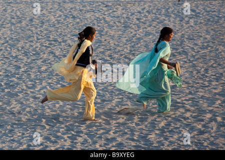 Les filles indiennes s'exécutant dans le sable en face du Taj Mahal à Agra Inde Banque D'Images