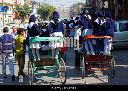 Ecolières Vélo pousse-pousse à la maison de l'école dans la région de Old Delhi Inde Banque D'Images