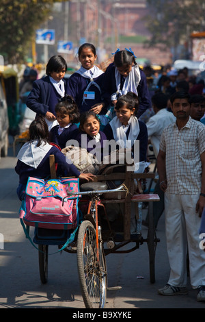 Ecolières Vélo pousse-pousse à la maison de l'école dans la région de Old Delhi Inde Banque D'Images