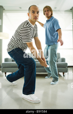 Deux hommes jouant avec les contrôleurs sans fil jeu vidéo Banque D'Images