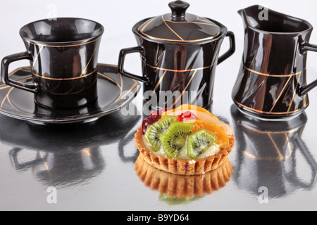 Flan aux fruits avec les kiwis de pêches et de cerises sur un fond réfléchissant Banque D'Images