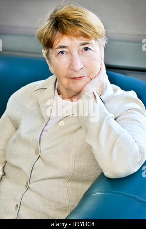 Femme âgée assise dans veste en lin blanc Banque D'Images