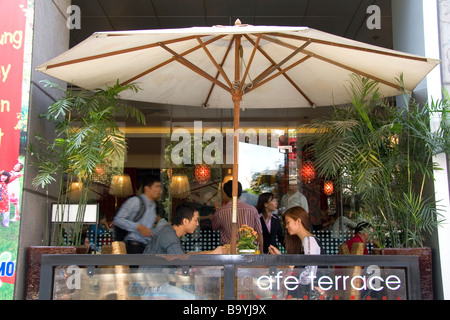 Couple vietnamien moderne manger le déjeuner dans un café-terrasse à Ho Chi Minh City Vietnam Banque D'Images