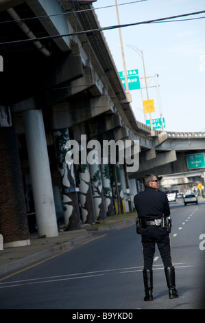 Agent de police de la Nouvelle Orléans en attente près de la I-16 près de la rampe Claiborne Avenue pour diriger le trafic pour un passage à niveau à flotteur Mardi Gras Banque D'Images