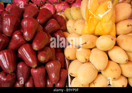 Close up de pommes et poire rouge jaune mûres mangues sur un étal de Bangkok Banque D'Images