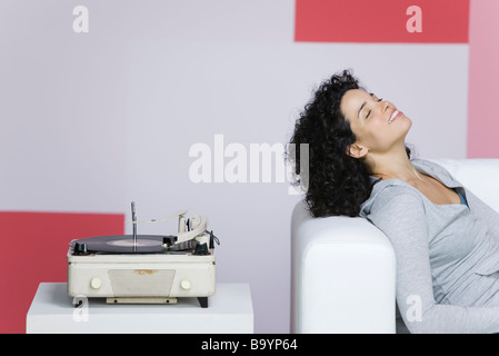 Woman enjoying music, écouter de vieux record player Banque D'Images