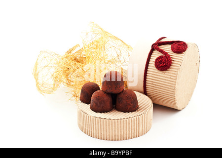 Truffes à la main sur une couverture de carton cadeau fond blanc Banque D'Images