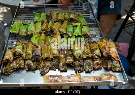 Gros plan sur des parcelles de bananes grillées enveloppées dans leurs feuilles dans un stand de Bangkok Banque D'Images