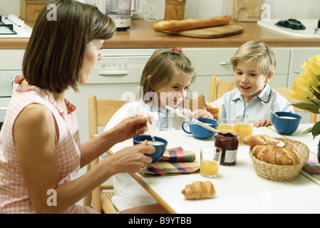 Famille assis à table pour le petit déjeuner Banque D'Images