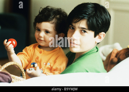 Boy holding petite sœur, smiling at camera Banque D'Images