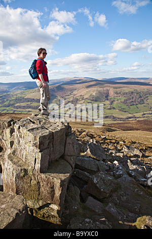 Walker sur sommet du mont Sugarloaf en regardant vers les Montagnes Noires Wales UK Banque D'Images