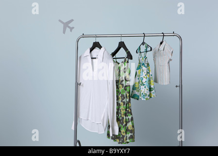 Vêtements d'été de la famille hanging on clothes rack, forme de l'avion en arrière-plan Banque D'Images