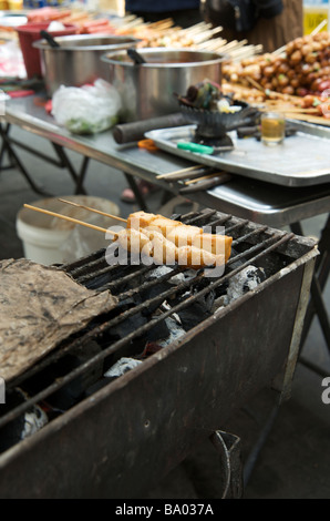 Un gros plan du poisson brochettes satay de poulet et sur un étal de Bangkok Banque D'Images