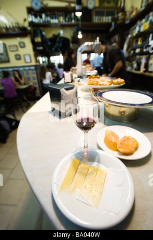 Assiette de fromage Manchego, à moitié fini verre de vin dans un bar à tapas Banque D'Images